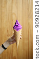 purple softserve with hand on wooden background 90928214