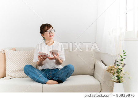 在家沙發上放鬆的時尚日本女性（閱讀、書籍、漫畫、小說） 90929976