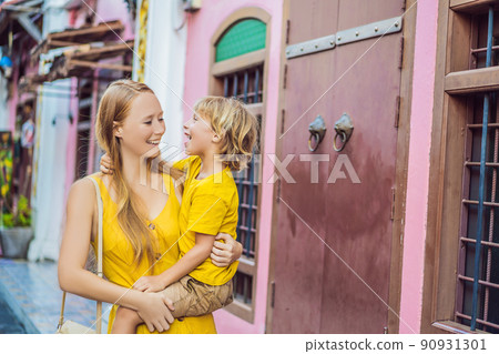 Mom and son tourists on the Street in the Portugese style Romani in Phuket Town. Also called Chinatown or the old town. Traveling with kids concept Mom and son tourists on the Street in the Portugese style Romani in Phuket Town. Also called Chinatown or the old town. Traveling with kids concept 90931301