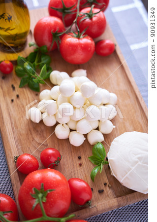 Ingredients for Caprese salad - Mini mozzarella cheese in glass bowl, tomato and basil Ingredients for Caprese salad - Mini mozzarella cheese in glass bowl, tomato and basil 90931349