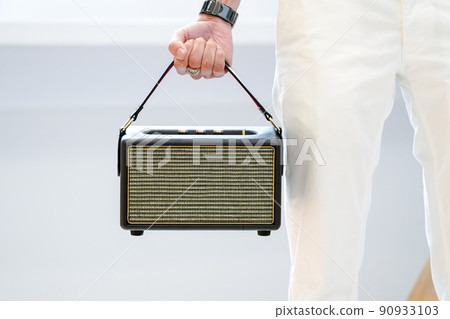 Asian man holding a luxury loudspeaker with his fist on white background. 90933103