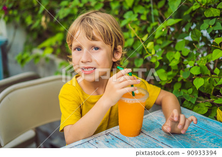 Sweet little caucasian boy, eating pancakes and drinking orange juice 90933394