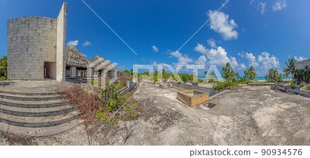 Picture of a destroyed, overgrown and left to itself hotel complex on a beach 90934576