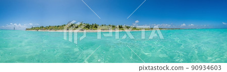 Panorama over a tropical beach taken from the water during the day with sunshine 90934603