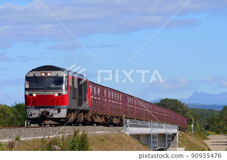 A temporary freight train dedicated to potatoes crossing a brand new bridge with Mt. Yubari in the background 90935476