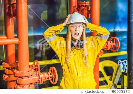 Young woman in a yellow work uniform, glasses and helmet in industrial environment,oil Platform or liquefied gas plant Young woman in a yellow work uniform, glasses and helmet in industrial environment,oil Platform or liquefied gas plant 90935573