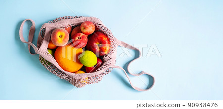 String mesh bag for grocery with various fruits. Reusable shopping tote bag, zero waste concept. String mesh bag for grocery with various fruits. Reusable shopping tote bag, zero waste concept. 90938476