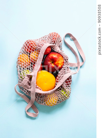 String mesh bag for grocery with various fruits. Reusable shopping tote bag, zero waste concept. 90938508