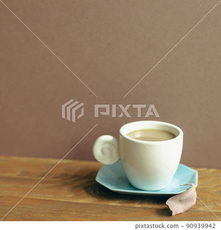 Cup of coffee on wooden table. brown wall background Cup of coffee on wooden table. brown wall background 90939942