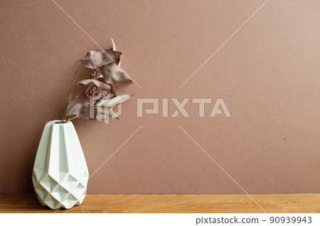 Vase of dry flowers on wooden table. brown wall background. home interior Vase of dry flowers on wooden table. brown wall background. home interior 90939943