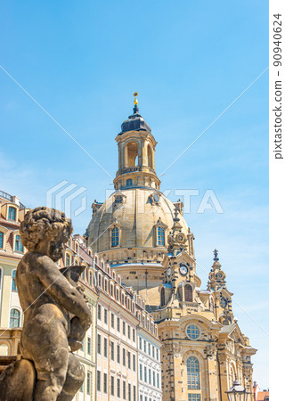 Church of Our Lady at Neumarkt square in downtown of Dresden in summer sunny day with blue sky copy space, Germany, and a statue of a child in foreground. Church of Our Lady at Neumarkt square in downtown of Dresden in summer sunny day with blue sky copy space, Germany, and a statue of a child in foreground. 90940624