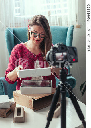 Close-up camera screen, woman blogger makes video of unpacking gadgets at home Close-up camera screen, woman blogger makes video of unpacking gadgets at home 90941170