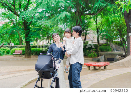 Family taking a walk while pushing a stroller 90942210