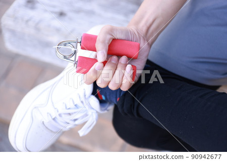Women doing grip training with hand grips 90942677