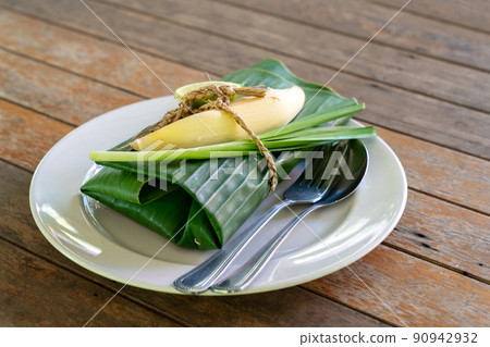 Wraped Thai food set cover by banana leaf ready to serve. Inside banana leaf is PadThai, The Traditional of Thailand Fried noodle with prawns. 90942932