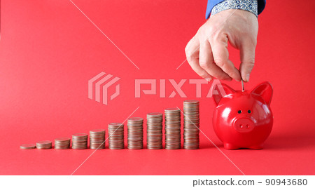 Male hand putting coin into piggy bank 90943680