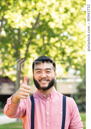 Vertical portrait of an asian man gesturing being well Vertical portrait of an asian man gesturing being well 90943732