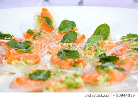 Salon spicy salad in Thai food style, in the plastic spoons on the dish that ready to serve in the event. Salon spicy salad in Thai food style, in the plastic spoons on the dish that ready to serve in the event. 90944059