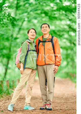 Senior couple walking in the fresh green mountains Senior couple walking in the fresh green mountains 90944428