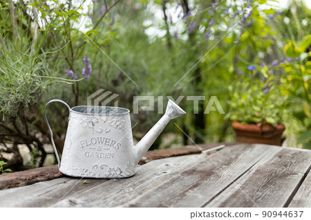 White tin watering can in the garden White tin watering can in the garden 90944637