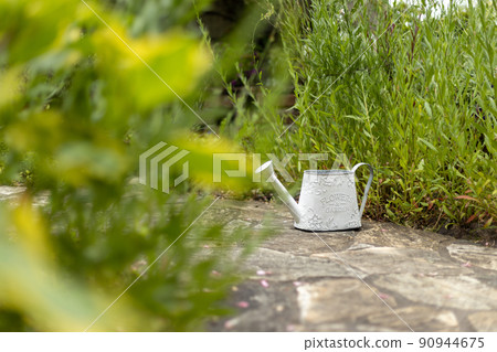 White tin watering can in the garden 90944675