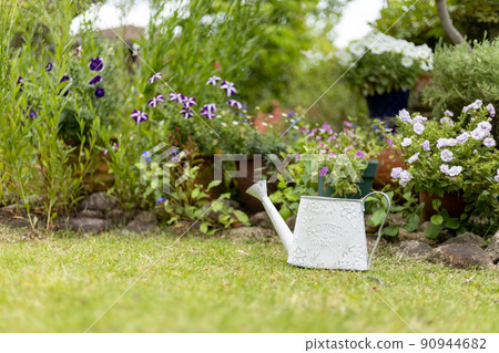 White tin watering can in the garden White tin watering can in the garden 90944682