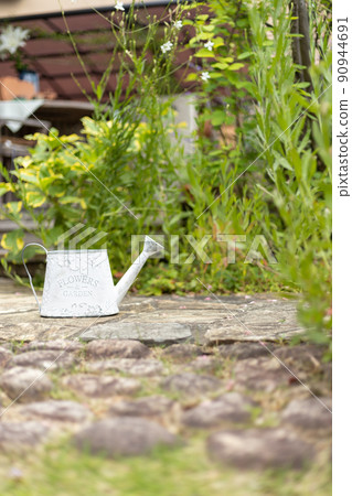 White tin watering can in the garden White tin watering can in the garden 90944691