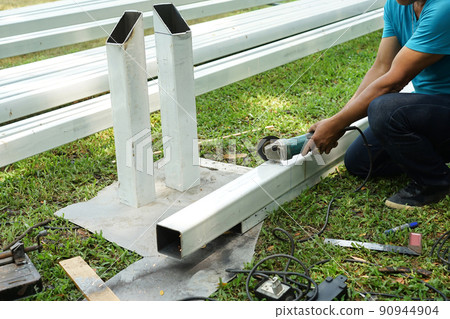 Asian smith are sawing the steel pole. Asian smith are sawing the steel pole. 90944904