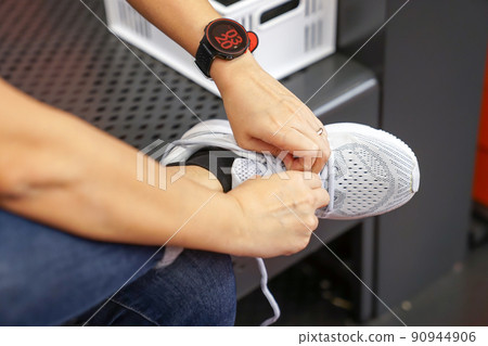 Asian woman is wearing and testing the sneaker in shoe store before to buy it Asian woman is wearing and testing the sneaker in shoe store before to buy it 90944906