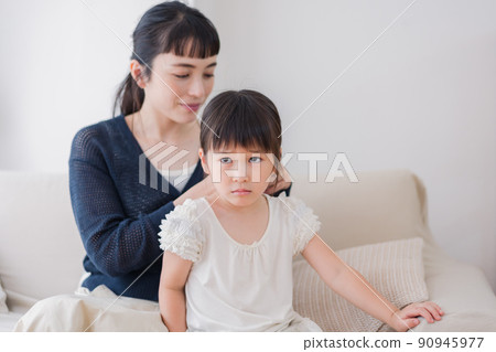 Mom tying her daughter's hair Mom tying her daughter's hair 90945977