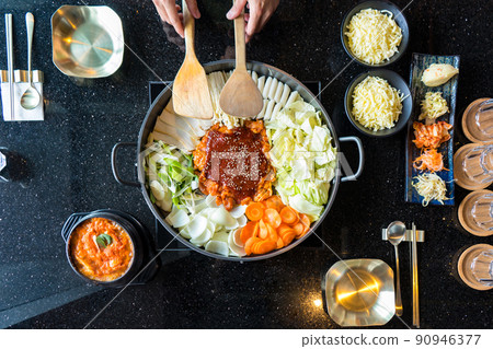 Tokboki (Korean tranditional food hot and spicy rice cake), combination and apply puff with cheese and vegetable on the black table Tokboki (Korean tranditional food hot and spicy rice cake), combination and apply puff with cheese and vegetable on the black table 90946377