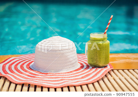 Green smoothies of spinach and banana on the background of the pool. Healthy food, healthy smoothies 90947555
