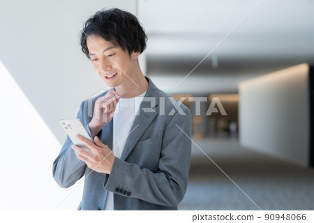 一個年輕的辦公室休閒商人談智能手機拍攝合作“LINK FOREST” 90948066