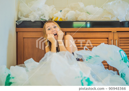 Woman used too many plastic bags that they filled up the entire kitchen. Zero waste concept. The concept of World Environment Day Woman used too many plastic bags that they filled up the entire kitchen. Zero waste concept. The concept of World Environment Day 90948366