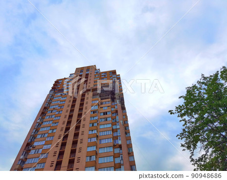 Kyiv, Ukraine - May 27, 2022: War of Russia against Ukraine. View of a civilian building damaged following a Russian rocket attack the city. Kyiv, Ukraine - May 27, 2022: War of Russia against Ukraine. View of a civilian building damaged following a Russian rocket attack the city. 90948686