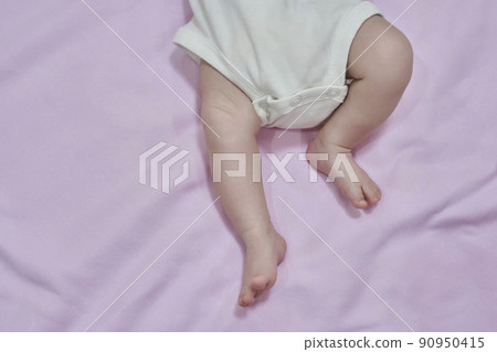 Low Section Of Baby Feet Relaxing Over Blanket. Feet of the infant lying on pink backgraund 90950415