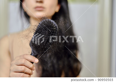 Female hairloss. Sad young woman with hair loss problem. Hair Loss problems. Woman with serious hair loss problem for health care Female hairloss. Sad young woman with hair loss problem. Hair Loss problems. Woman with serious hair loss problem for health care 90950503