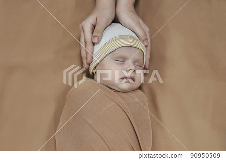 Young mother wears little baby girls headwear. Motherhood, sweet family, cute newborn baby girl. Little fashionable muslim baby girl wearing turban 90950509