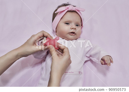 Mother hand giving plastic soother pacifier to little cute sleeping newborn baby Mother hand giving plastic soother pacifier to little cute sleeping newborn baby 90950573
