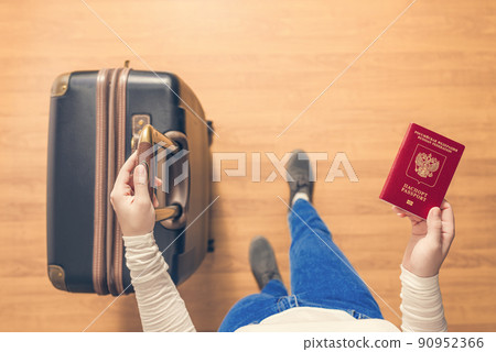 Top view of a girl with a suitcase and a Russian passport walking on the airport to passport control. Top view of a girl with a suitcase and a Russian passport walking on the airport to passport control. 90952366