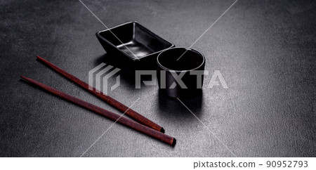 Wooden sushi sticks on a dark concrete background Wooden sushi sticks on a dark concrete background 90952793