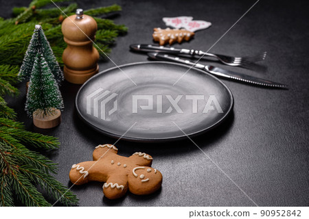 An empty wooden cutting board with wooden cutlery on a christmas kitchen table 90952842