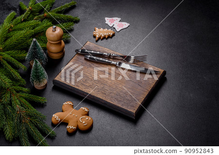 An empty wooden cutting board with wooden cutlery on a christmas kitchen table 90952843