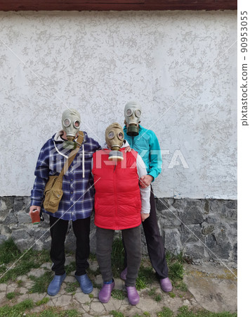 Gas masks. Three people with gas masks and brick wall behind with copy space. Danger of chemical weapon. 90953055