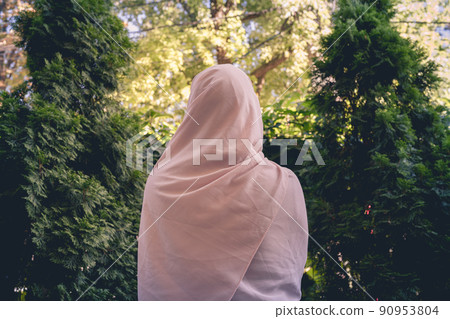 Autumn. Lonely muslim woman in a headscarf walking in a park, garden. Vintage Toned Autumn. Lonely muslim woman in a headscarf walking in a park, garden. Vintage Toned 90953804