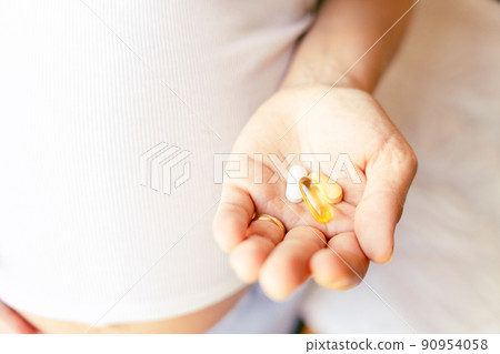 Maternal supplements pill. Happy smiling woman taking pill with supplement vitamin Omega 3. Pregnancy, medicine health care concept. 90954058