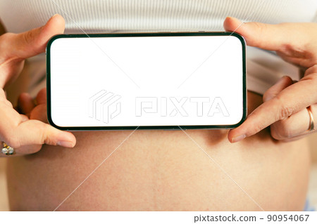 Pregnancy mockup display. Pregnant woman holding smartphone. Mobile pregnancy online maternity application mock up. Concept maternity, pregnancy, childbirth. Pregnancy mockup display. Pregnant woman holding smartphone. Mobile pregnancy online maternity application mock up. Concept maternity, pregnancy, childbirth. 90954067