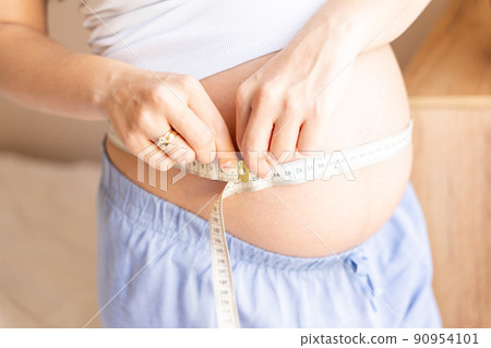 Pregnant belly woman measure. Happy beautiful pregnant woman with tape measuring belly. Pregnancy, medicine health care concept. Pregnant belly woman measure. Happy beautiful pregnant woman with tape measuring belly. Pregnancy, medicine health care concept. 90954101