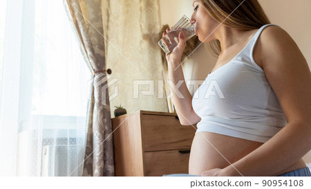 Pregnant drinking water. Young pregnancy mother drink water. Pregnant lady waiting of baby. Glass of water. Concept maternity, childbirth. 90954108