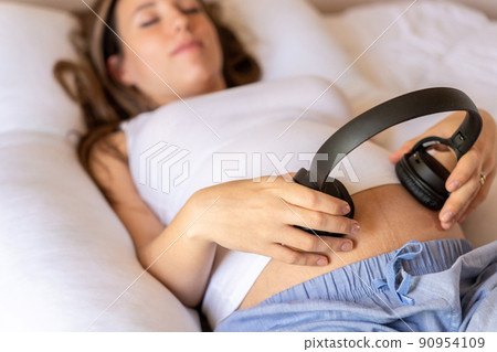 Pregnancy therapy music. Pregnant woman listening to music. Mother belly listen headphones sound. Pregnancy, medicine health care and people concept. Pregnancy therapy music. Pregnant woman listening to music. Mother belly listen headphones sound. Pregnancy, medicine health care and people concept. 90954109